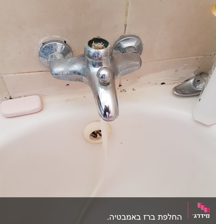 ברז אמבטיה עם ידית חסרה ומים זורמים